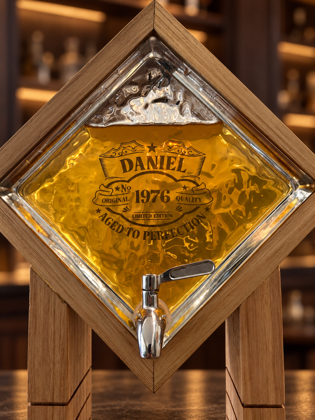 Custom laser engraving on textured glass whiskey dispenser filled with amber whisky with silver spigot 