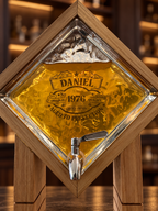Custom laser engraving on textured glass whiskey dispenser filled with amber whisky with silver spigot 