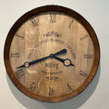 wine barrel wall clock with Roman numerals and engraved text on a plain background
