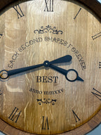 Close-up of handcrafted wine barrel clock face made from reclaimed oak barrel head with Roman numerals.