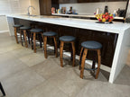 Wine barrel bar stools in a modern Australian kitchen with black padded seats