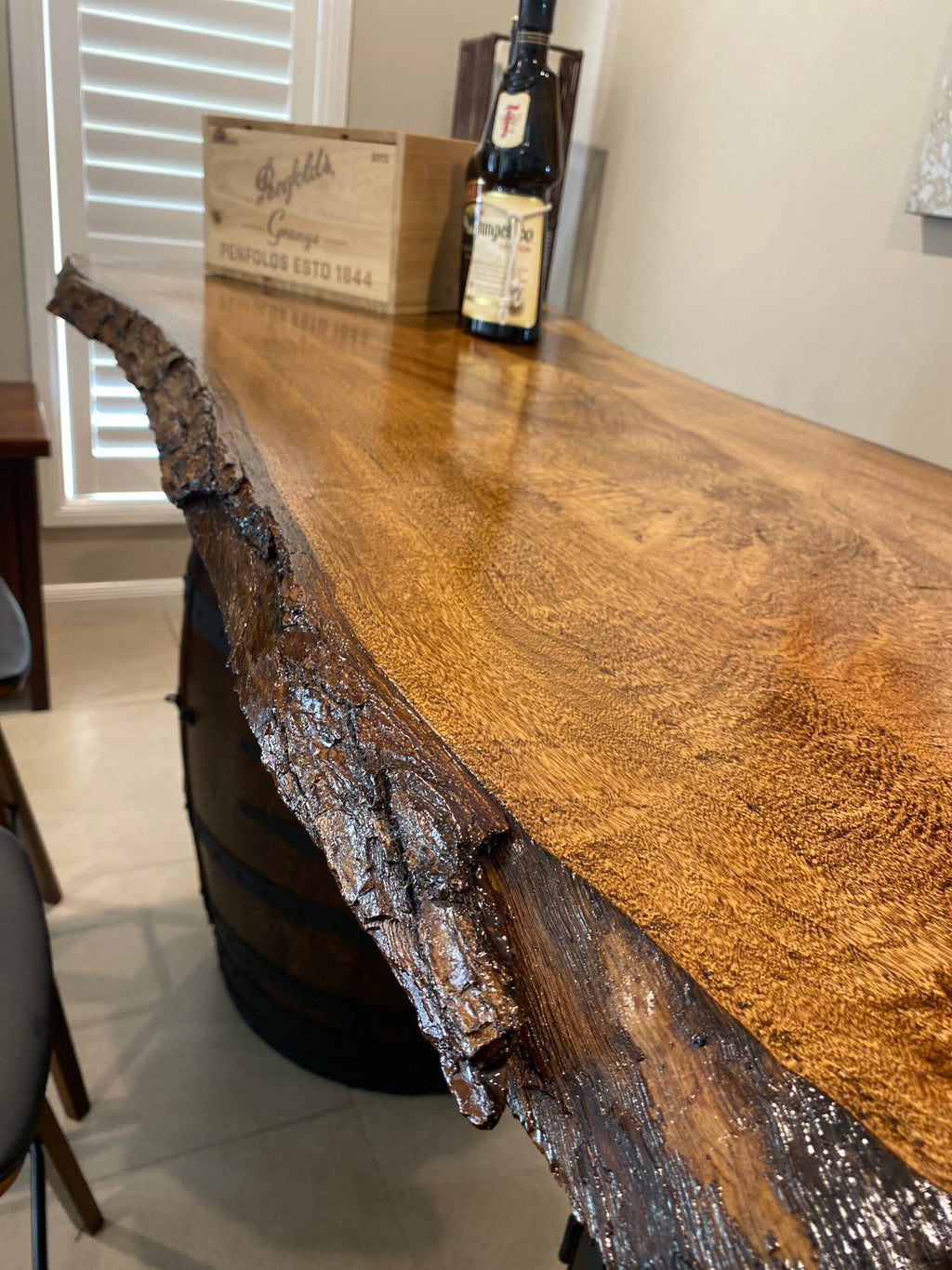 Rustic wine barrel bar with live edge wood slab top and hidden storage – handcrafted with built-in shelves for bottles and glassware
