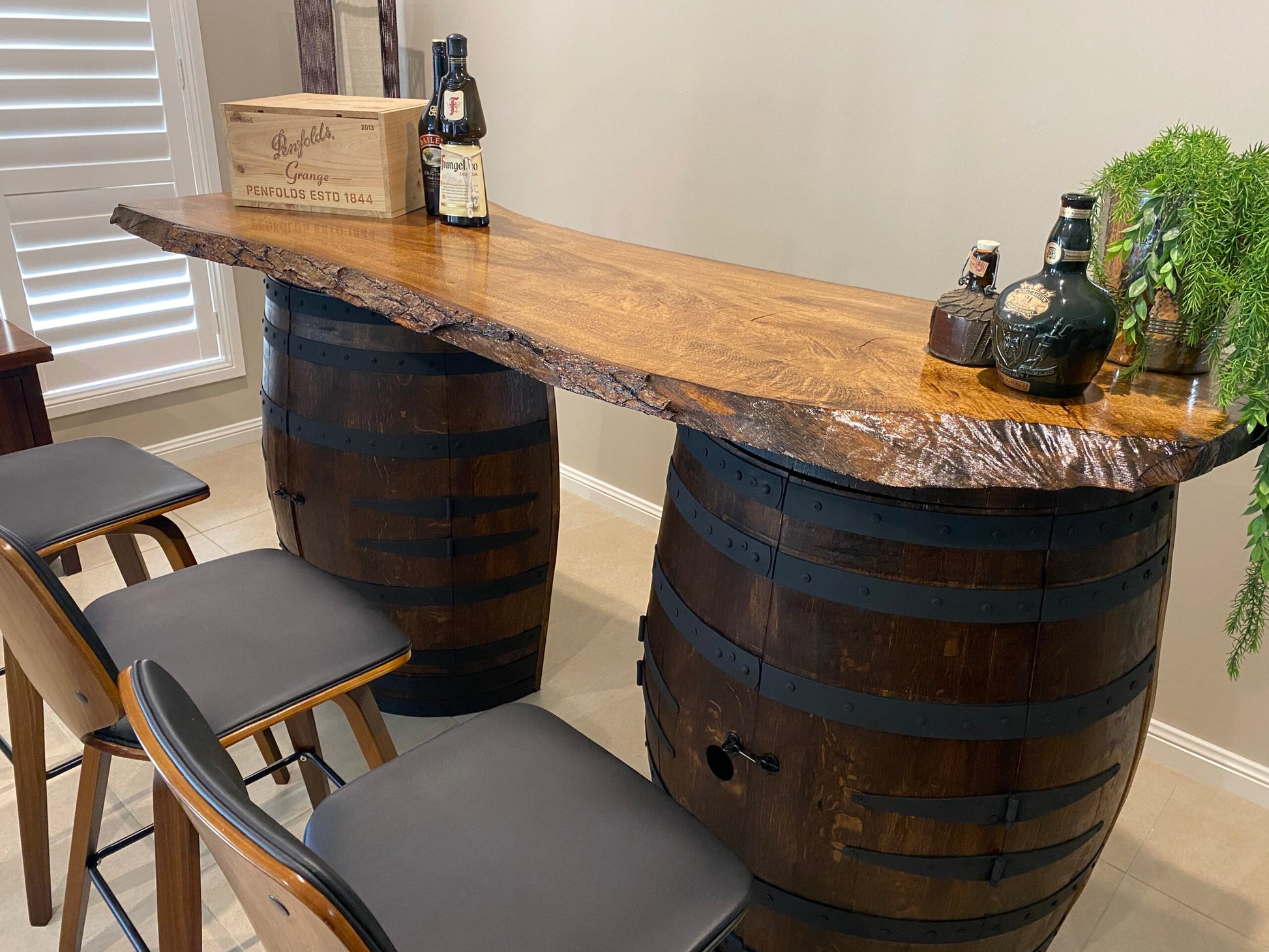 Rustic wine barrel bar with live edge wood slab top and hidden storage – handcrafted with built-in shelves for bottles and glassware