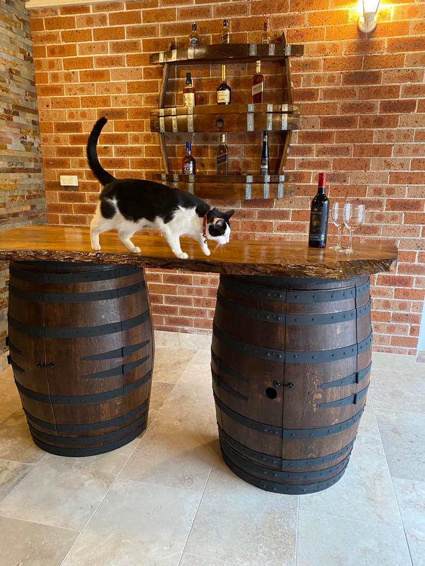 Rustic wine barrel bar with live edge wood slab top and hidden storage – handcrafted with built-in shelves for bottles and glassware