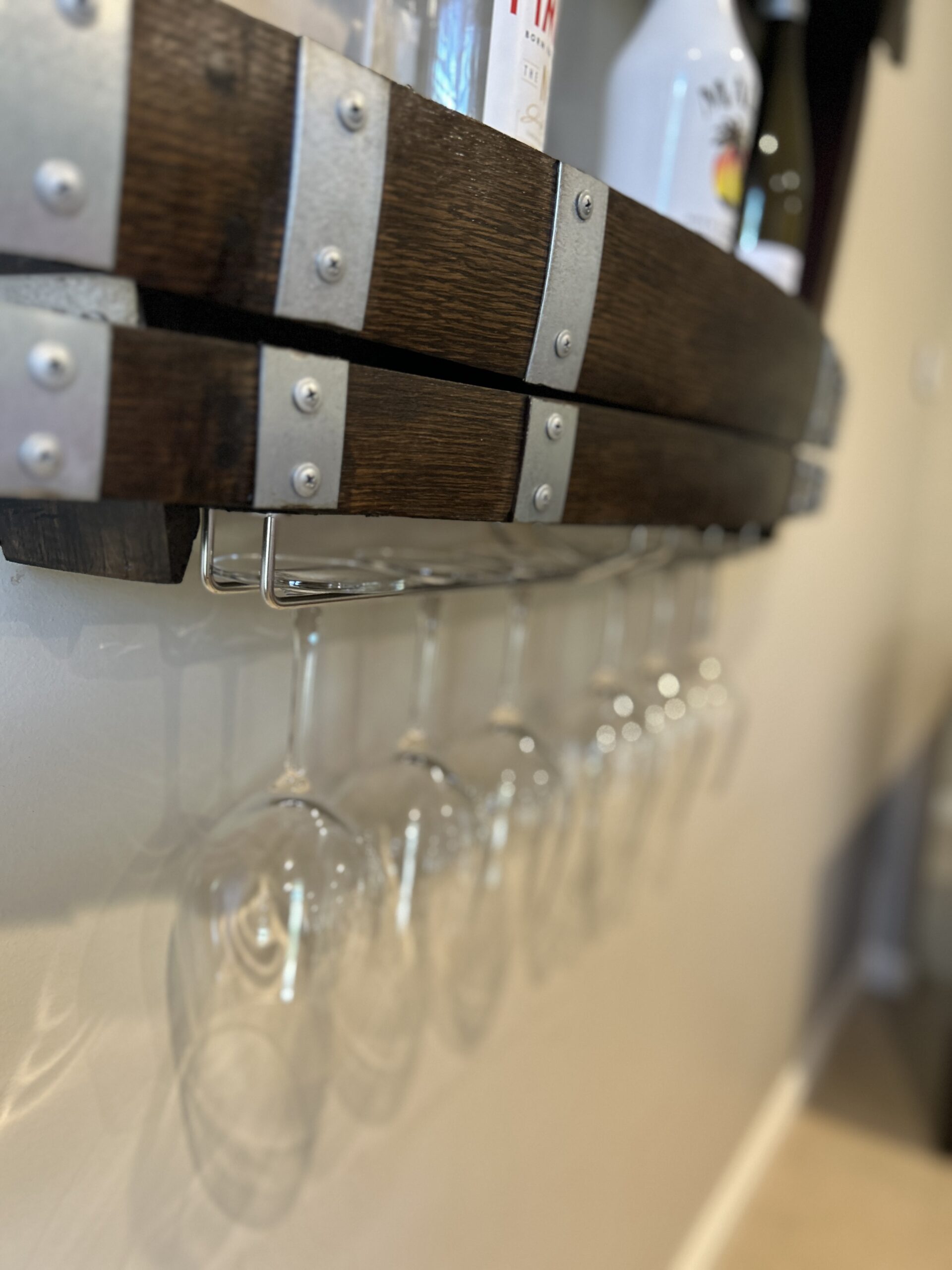 Wine barrel spirit rack handcrafted from reclaimed oak, featuring internal shelving and bottle storage – perfect for displaying whisky, wine, or barware