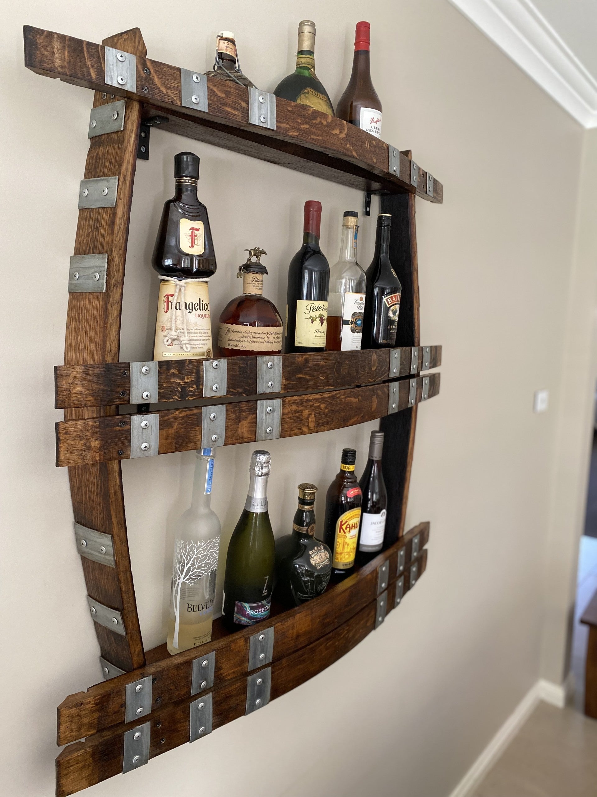 Wine barrel spirit rack handcrafted from reclaimed oak, featuring internal shelving and bottle storage – perfect for displaying whisky, wine, or barware