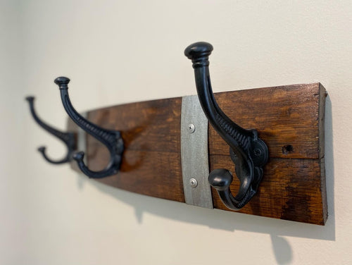 Rustic wine barrel coat rack handcrafted from reclaimed oak barrels with metal hooks – sustainable and stylish wall-mounted entryway organise