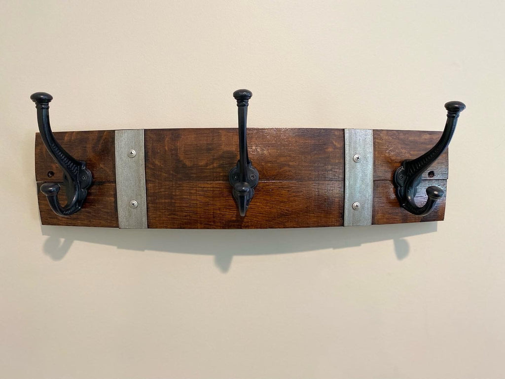 Rustic wine barrel coat rack handcrafted from reclaimed oak barrels with metal hooks – sustainable and stylish wall-mounted entryway organise