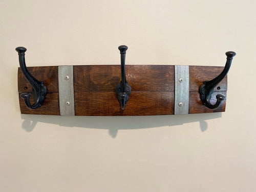 Rustic wine barrel coat rack handcrafted from reclaimed oak barrels with metal hooks – sustainable and stylish wall-mounted entryway organise