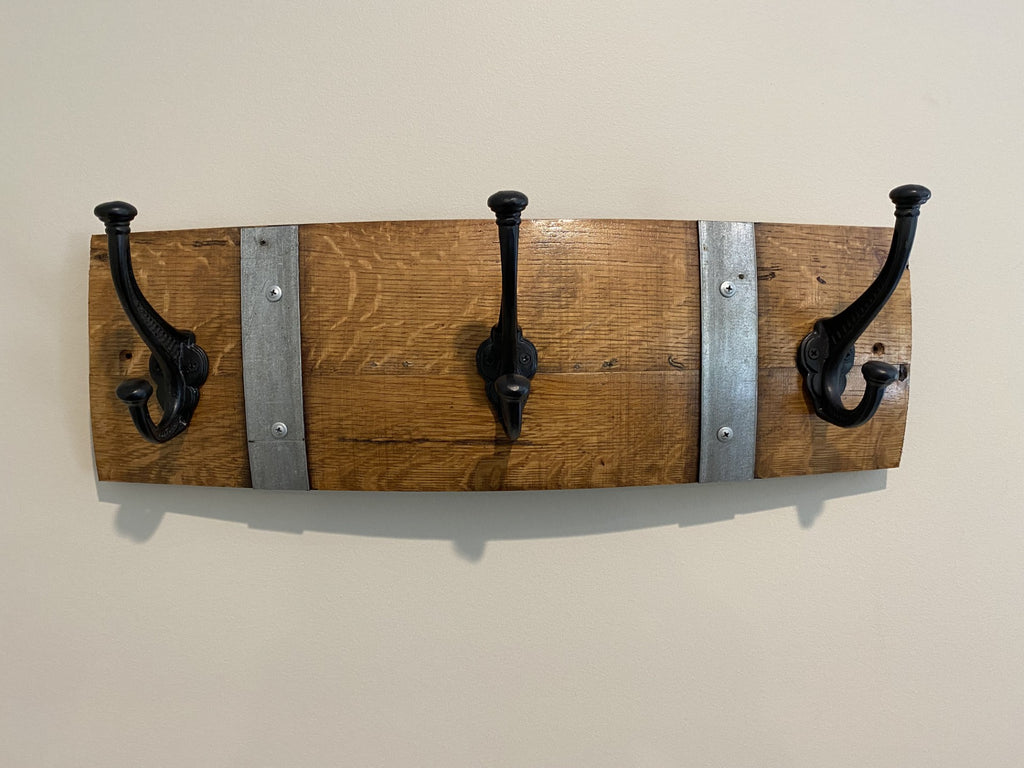 Rustic wine barrel coat rack handcrafted from reclaimed oak barrels with metal hooks – sustainable and stylish wall-mounted entryway organise