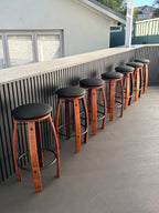 Handcrafted wine barrel bar stools in a home bar
